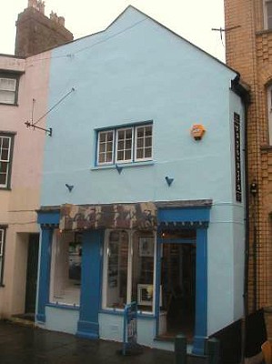 White rendered gable with blue shop front.